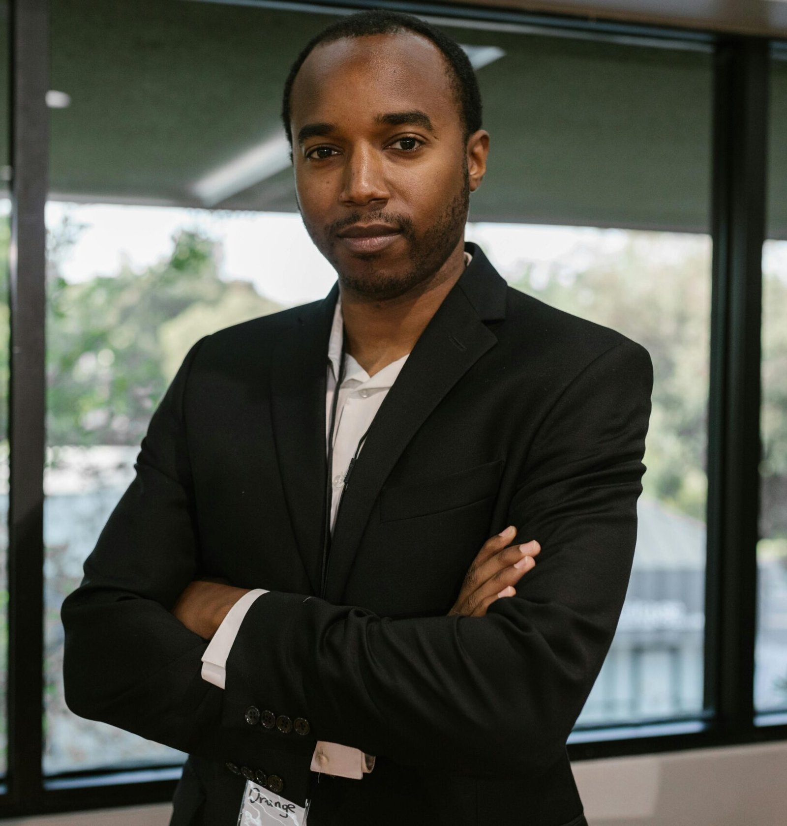 Portrait of a confident man in corporate attire inside a modern office.